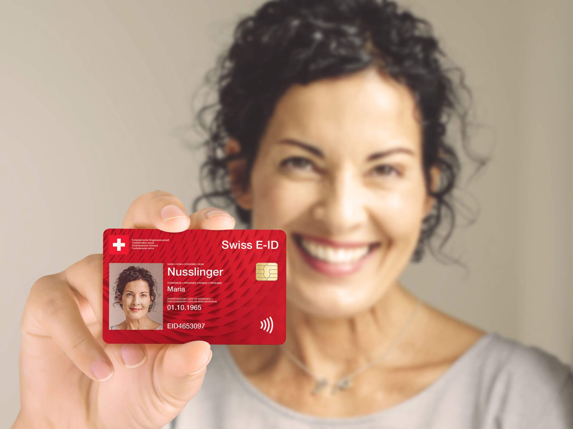 Eine Person hält eine E-ID in Kreditkartenformat vor die Kamera